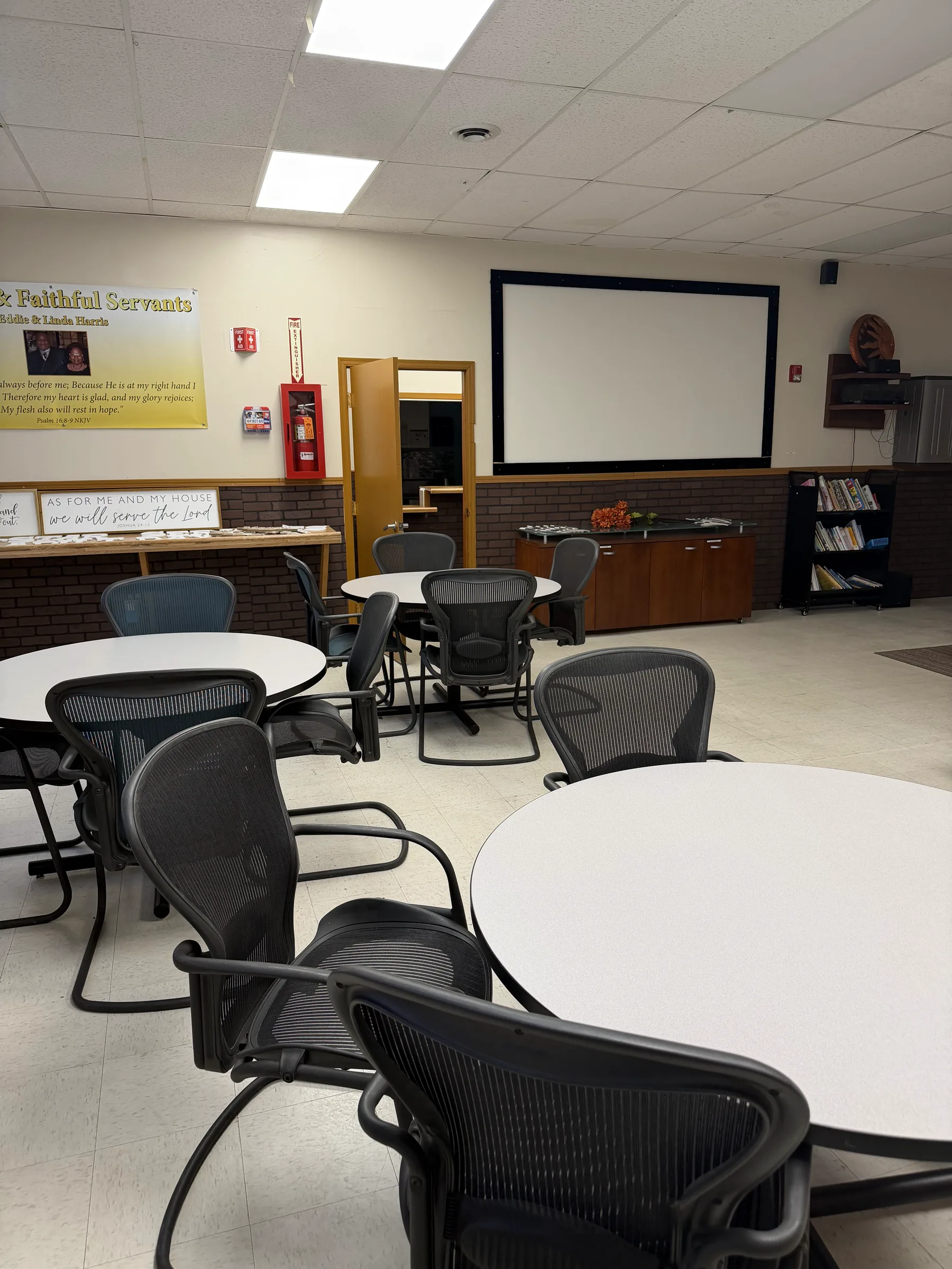 Classroom and training room with tables, chairs, and a projection screen.